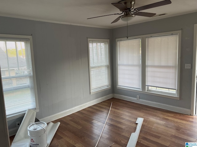 unfurnished room with ceiling fan, ornamental molding, and dark wood-type flooring