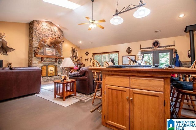 kitchen featuring a fireplace, vaulted ceiling, and ceiling fan