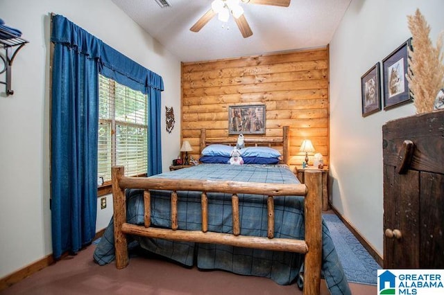 bedroom featuring log walls and ceiling fan