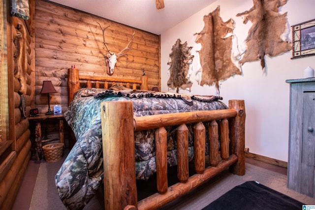 bedroom with carpet floors and log walls