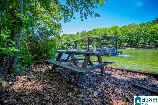 view of home's community with a water view and a dock