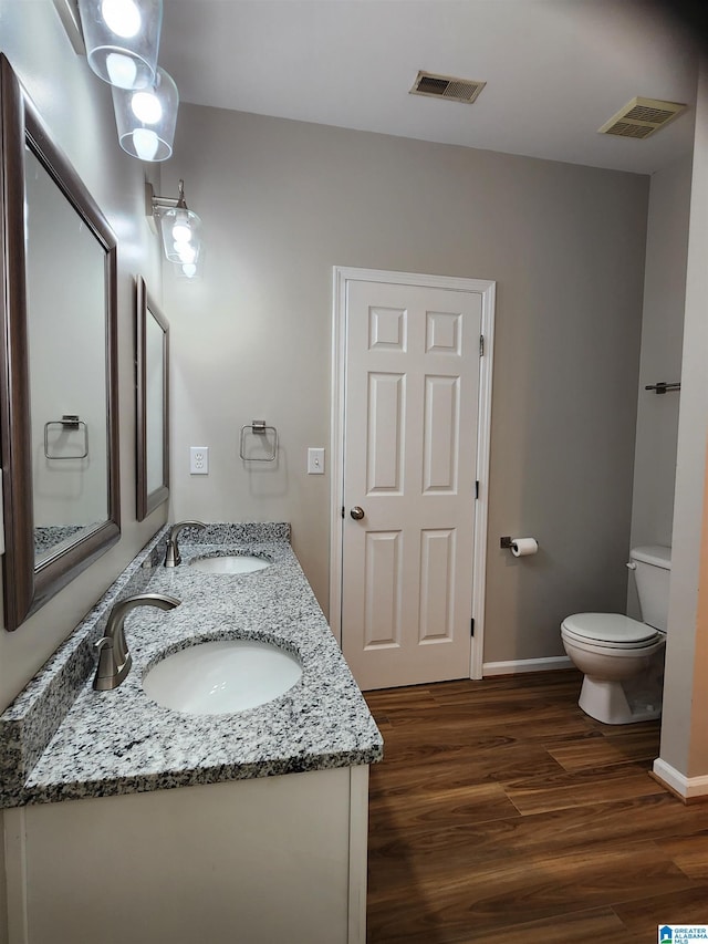 bathroom featuring visible vents, a sink, toilet, and wood finished floors