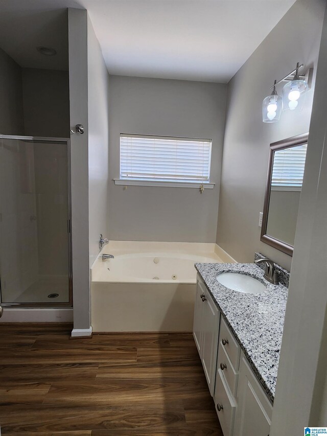 bathroom featuring separate shower and tub, a healthy amount of sunlight, hardwood / wood-style flooring, and large vanity