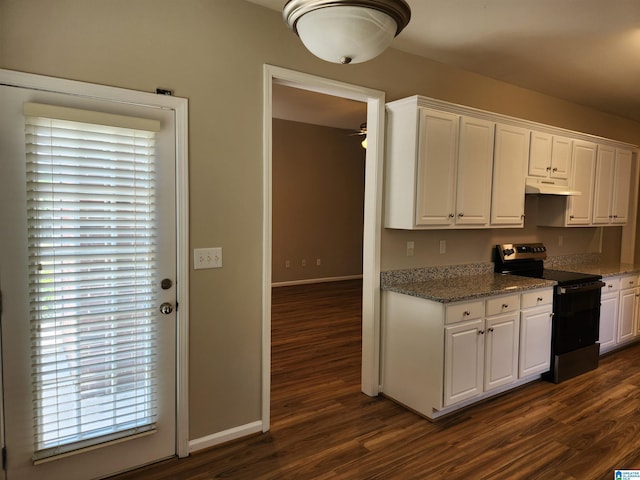 kitchen with under cabinet range hood, white cabinets, electric stove, dark wood-style floors, and dark stone countertops