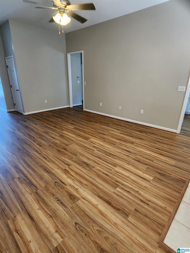 empty room with ceiling fan and hardwood / wood-style flooring