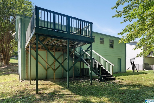 rear view of property featuring a wooden deck, a yard, and cooling unit