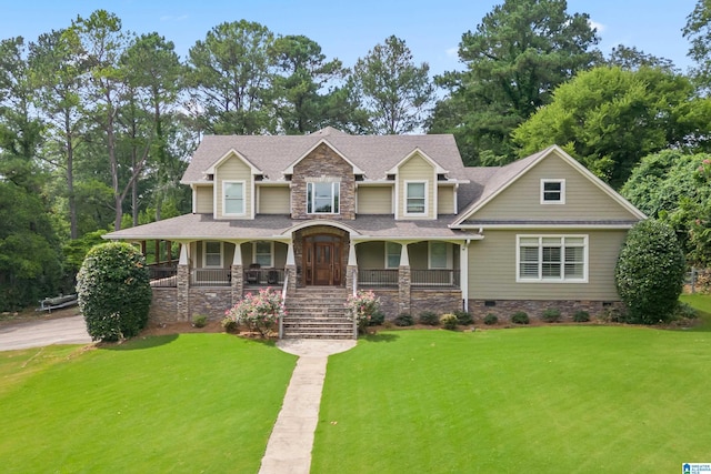 craftsman inspired home featuring covered porch and a front lawn