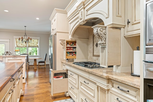 kitchen with a center island, an inviting chandelier, hanging light fixtures, and appliances with stainless steel finishes