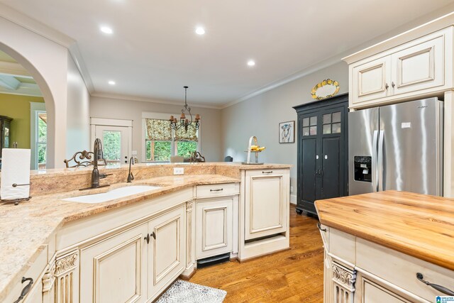 kitchen featuring ceiling fan, sink, ornamental molding, and cream cabinetry