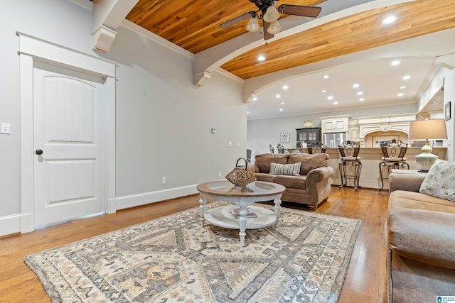 living room with a stone fireplace, crown molding, ceiling fan, wood-type flooring, and wood ceiling