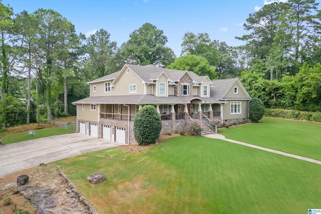 view of front of home featuring a front lawn, covered porch, and a garage