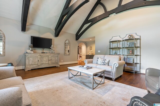 living room featuring ceiling fan, hardwood / wood-style floors, beamed ceiling, and high vaulted ceiling