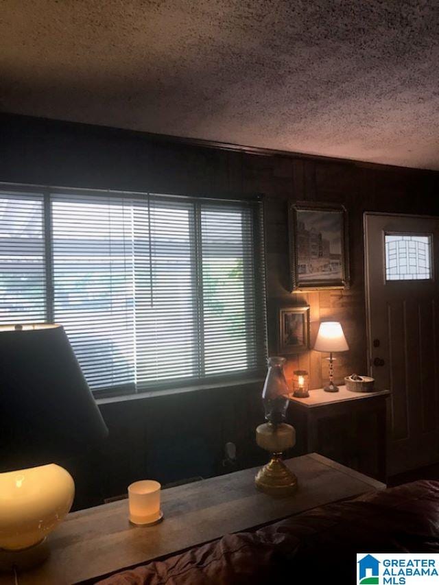 interior space with a textured ceiling and wooden walls