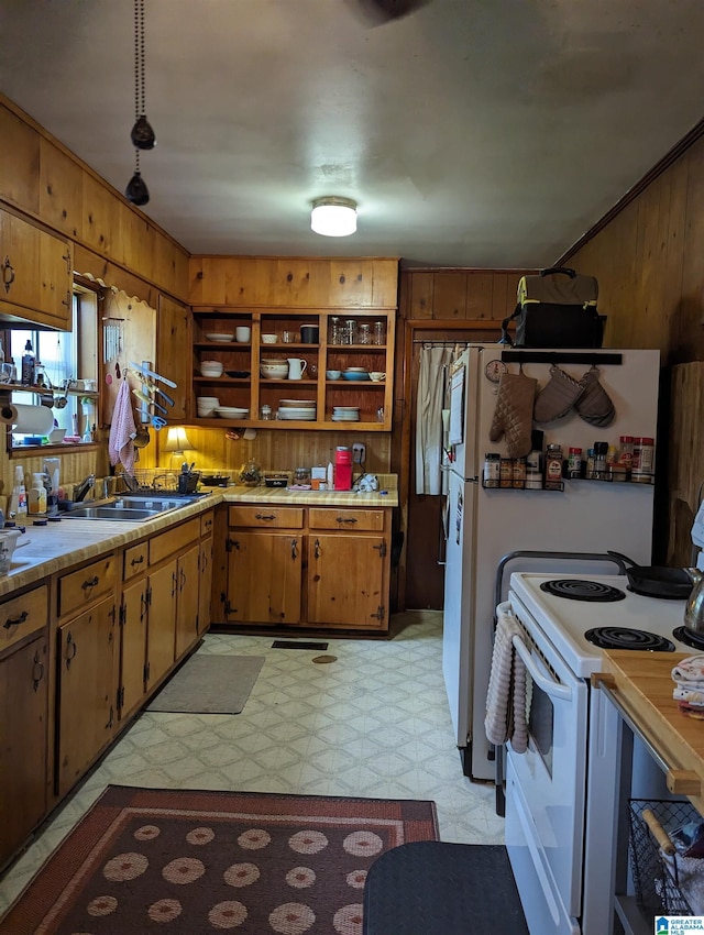 kitchen featuring wooden walls, sink, and white electric stove