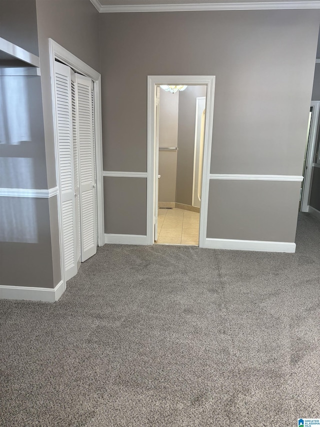 unfurnished bedroom featuring light colored carpet, crown molding, and a closet