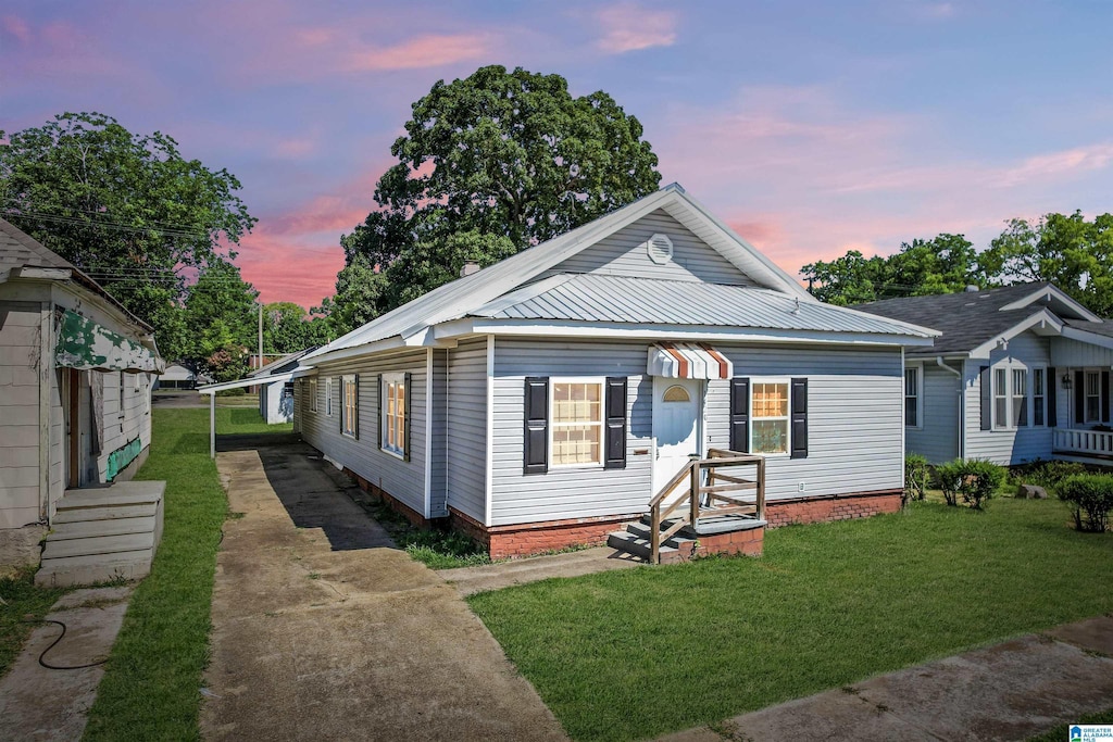 bungalow-style house with a carport and a lawn