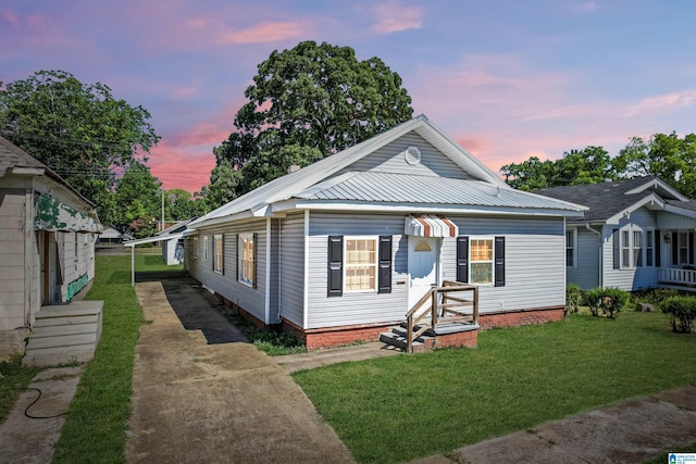 bungalow-style house with a carport and a lawn