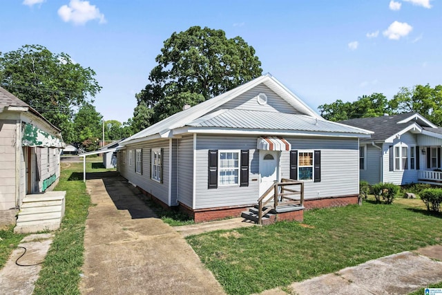 bungalow-style house featuring a front yard and a carport