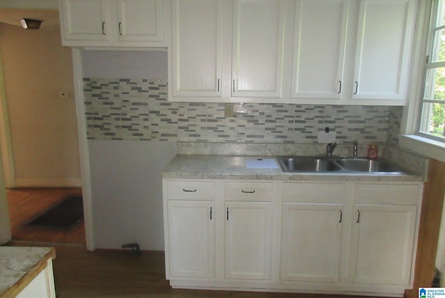 kitchen featuring tasteful backsplash, white cabinetry, and sink