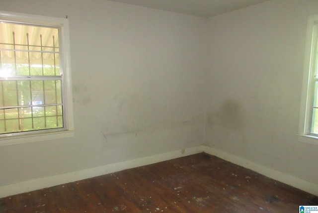 empty room with a healthy amount of sunlight and dark hardwood / wood-style flooring