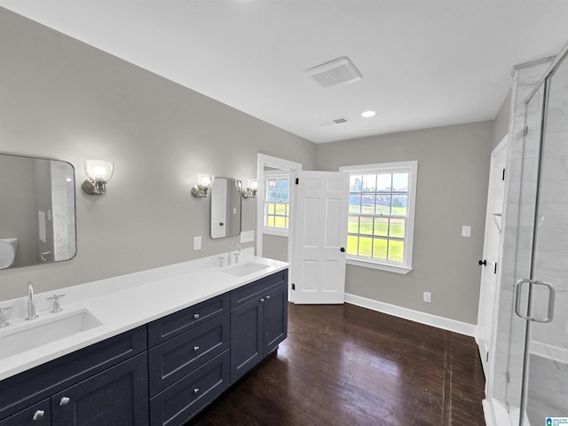 bathroom with hardwood / wood-style floors, vanity, and an enclosed shower