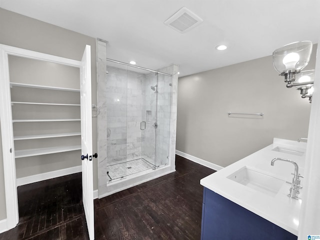 bathroom with hardwood / wood-style floors, vanity, and an enclosed shower