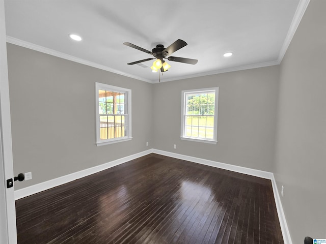 empty room featuring a wealth of natural light, dark hardwood / wood-style flooring, ceiling fan, and crown molding