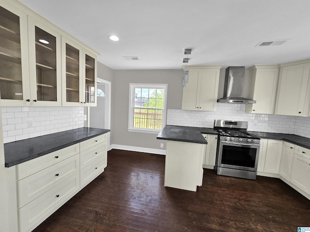 kitchen featuring gas stove, dark wood-type flooring, hanging light fixtures, and wall chimney exhaust hood