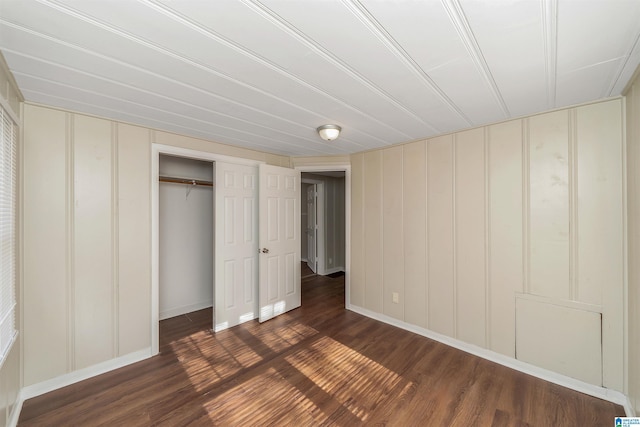 unfurnished bedroom featuring dark hardwood / wood-style floors and a closet