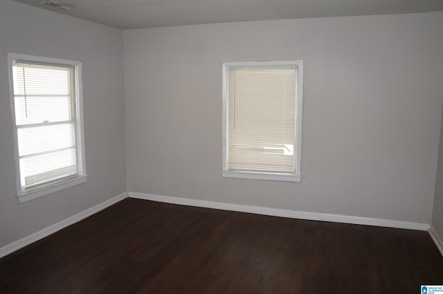 empty room with dark hardwood / wood-style flooring