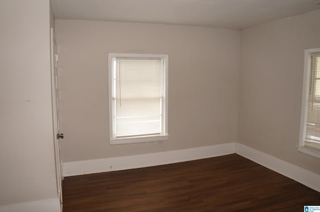 unfurnished room with a healthy amount of sunlight and dark hardwood / wood-style floors