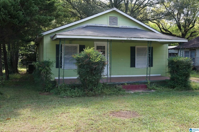 bungalow-style home with a front yard and covered porch