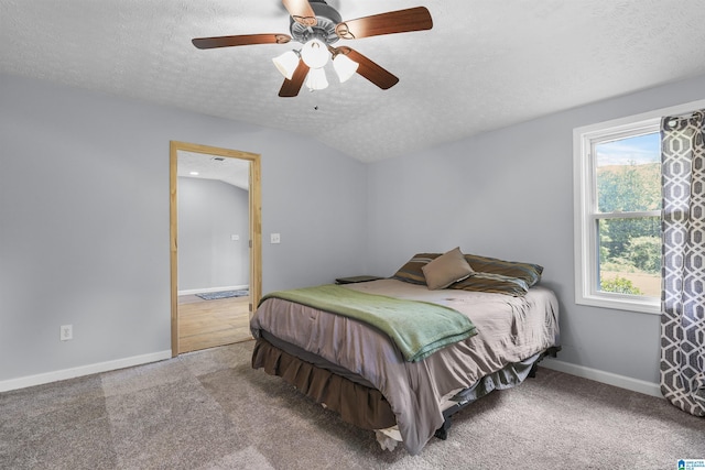 bedroom featuring ceiling fan, lofted ceiling, carpet, and a textured ceiling