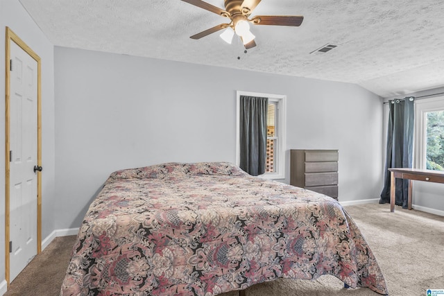 carpeted bedroom featuring ceiling fan, lofted ceiling, and a textured ceiling