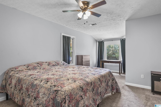 bedroom with vaulted ceiling, carpet flooring, a textured ceiling, and ceiling fan