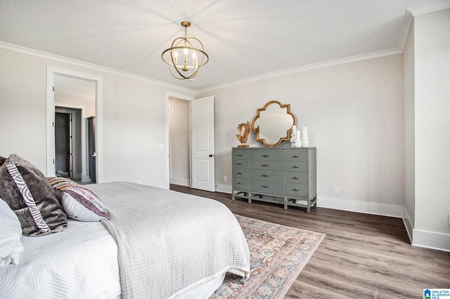 bedroom with a notable chandelier, crown molding, baseboards, and wood finished floors