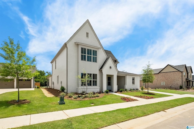 view of front facade with a garage, brick siding, and a front yard