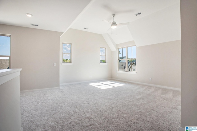 additional living space featuring carpet floors, vaulted ceiling, visible vents, and ceiling fan