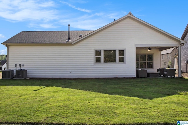 rear view of property featuring cooling unit, an outdoor living space, a ceiling fan, and a yard