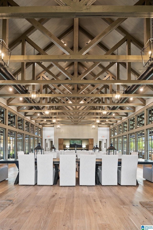 interior space with high vaulted ceiling, beamed ceiling, and light wood-style flooring