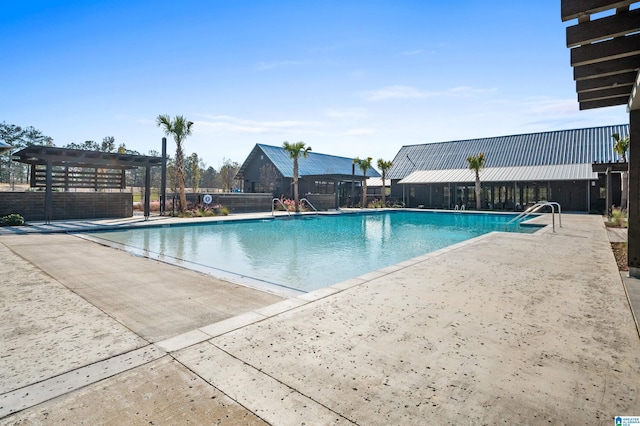 community pool with a patio area, fence, and a pergola