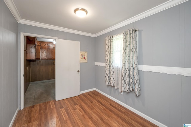 spare room featuring crown molding and hardwood / wood-style floors