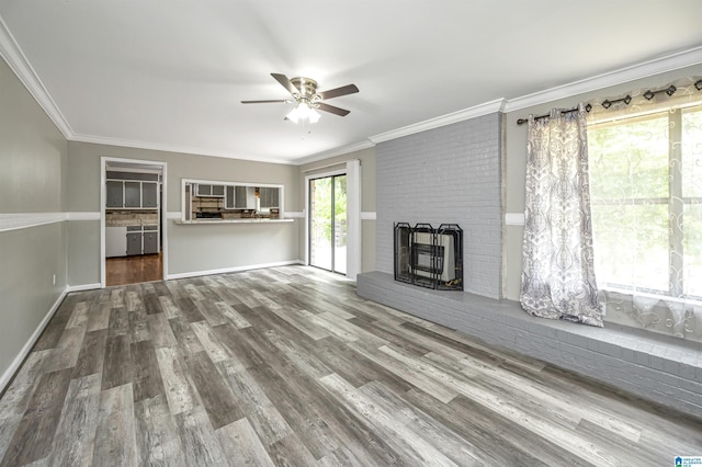 unfurnished living room with ceiling fan, a brick fireplace, ornamental molding, and hardwood / wood-style flooring