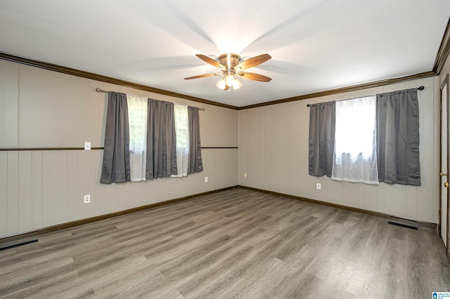 spare room with ceiling fan, ornamental molding, and light hardwood / wood-style floors