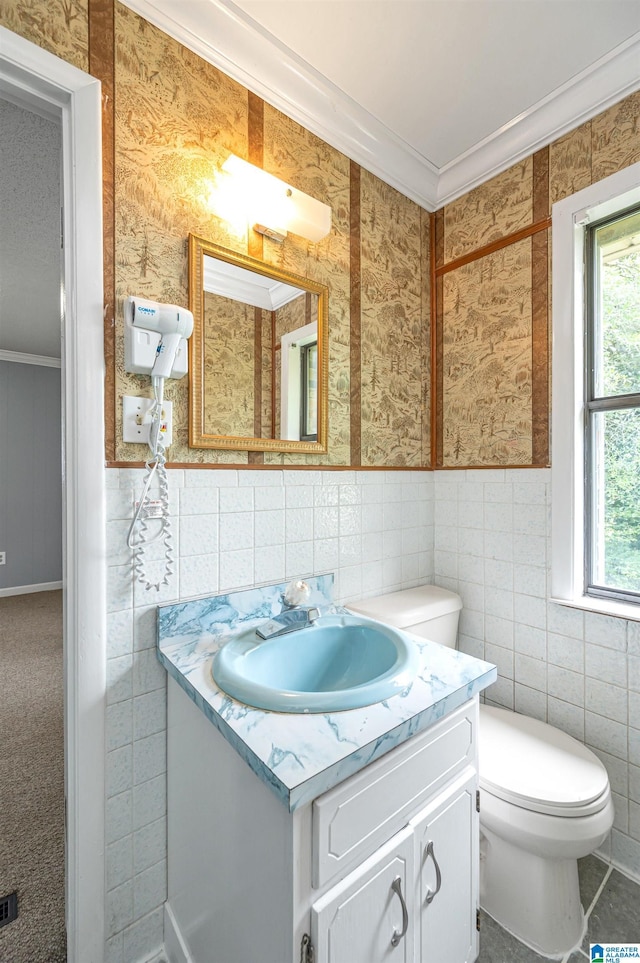 bathroom with toilet, ornamental molding, tile walls, and vanity