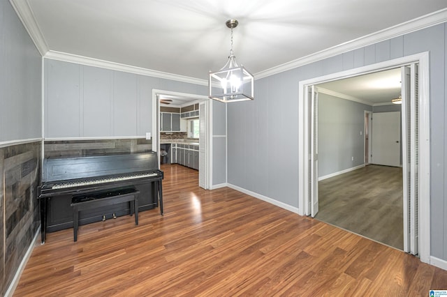 dining area with ornamental molding, a chandelier, and hardwood / wood-style floors