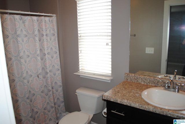 bathroom with toilet, a shower with shower curtain, and vanity