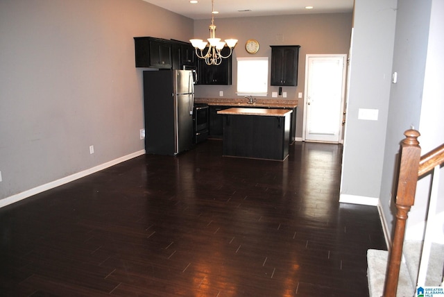 kitchen featuring a notable chandelier, a center island, hanging light fixtures, sink, and stainless steel appliances