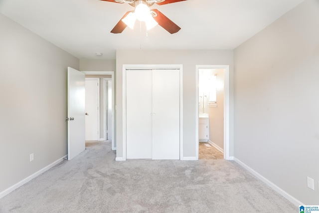 unfurnished bedroom featuring ceiling fan, a closet, ensuite bathroom, and light carpet