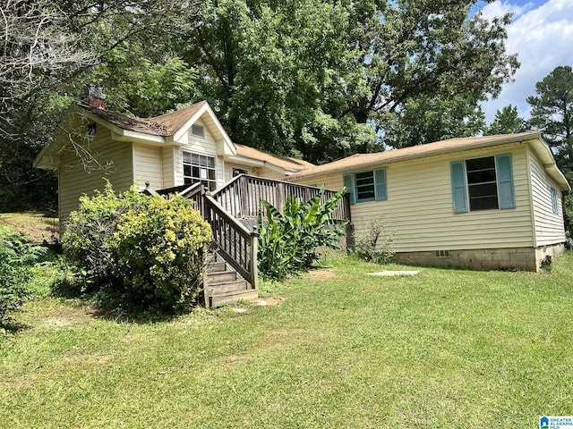 back of house featuring a yard and a wooden deck